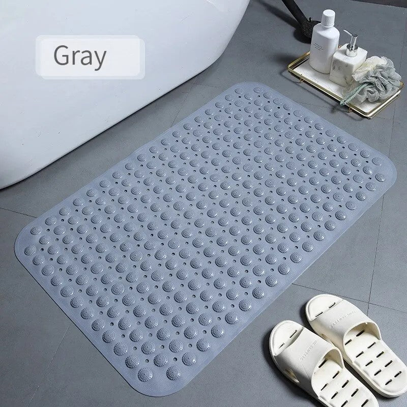 Gray anti-skid bath mat near bathtub with white slippers
