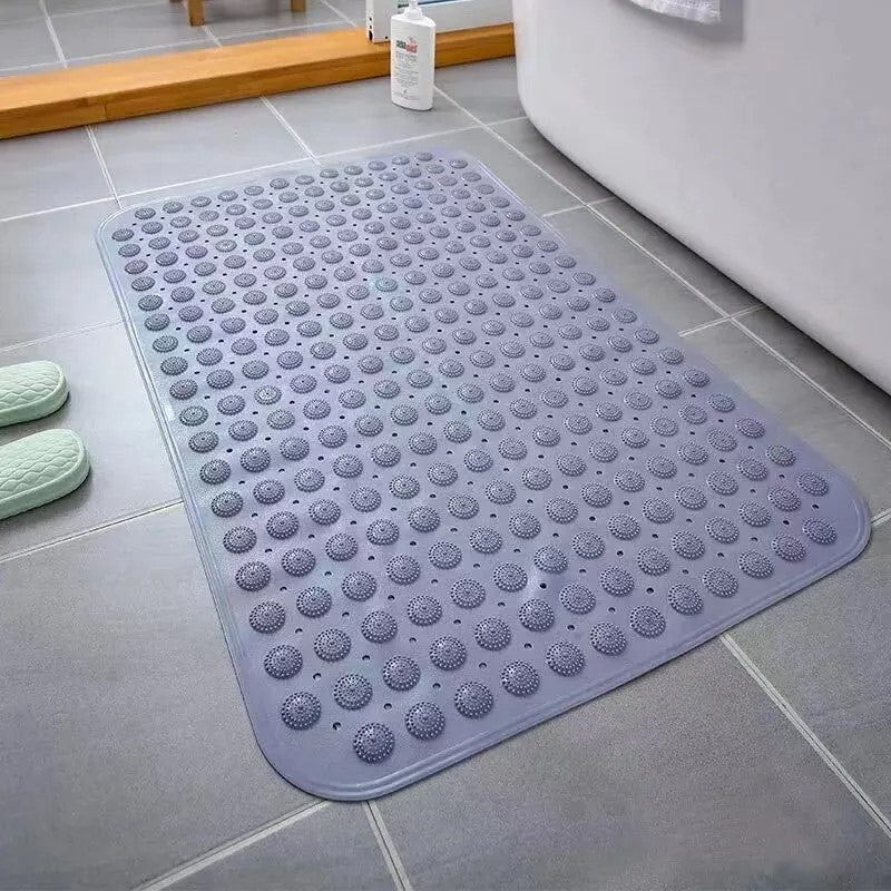 Gray bath mat with suction cups placed beside bathtub