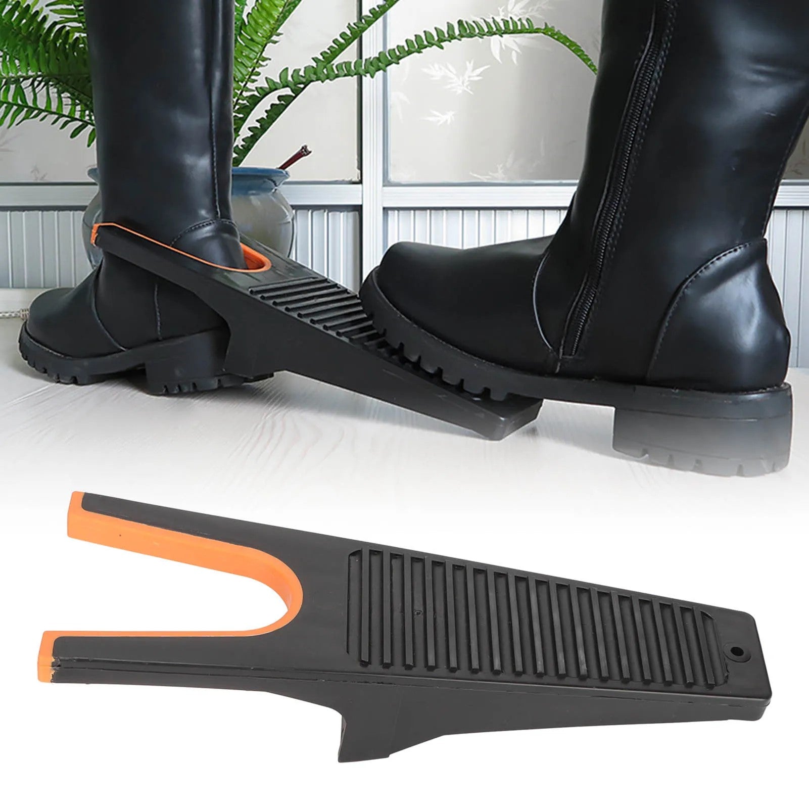 A black and orange easy grip boot remover tool in use, assisting in removing black cowboy boots, placed on a white floor with green plants in the background
