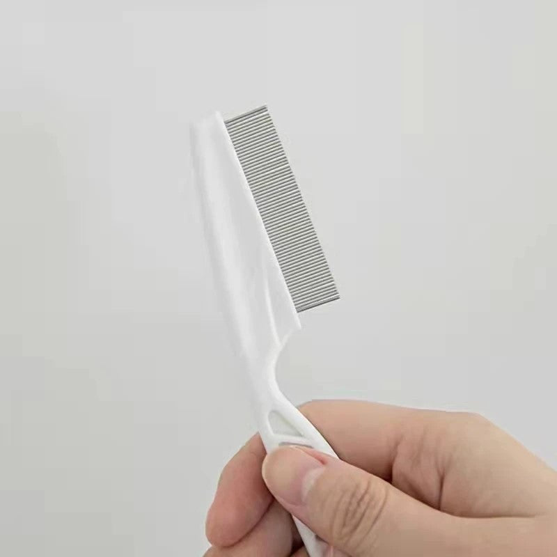 White pet facial cleaning brush for small dogs held in hand, close-up on white background